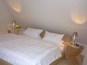 Das Schlafzimmer des Appartments. Doppelbett mit Nachtschr&auml;nkchen.