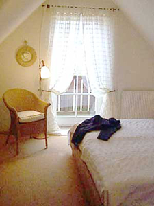 Schlafzimmer des Appartments des Darsser Teekatens mit Blick auf den Balkon