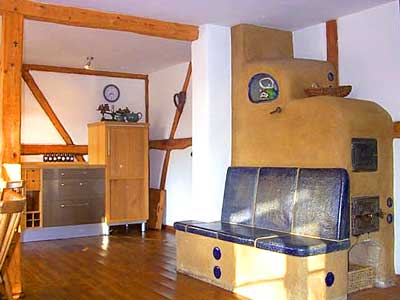 K&uuml;che und Wohnraum der gro&szlig;en Ferienwohnung. Mit Lehmofen, Dielenb&ouml;den und Fachwerk